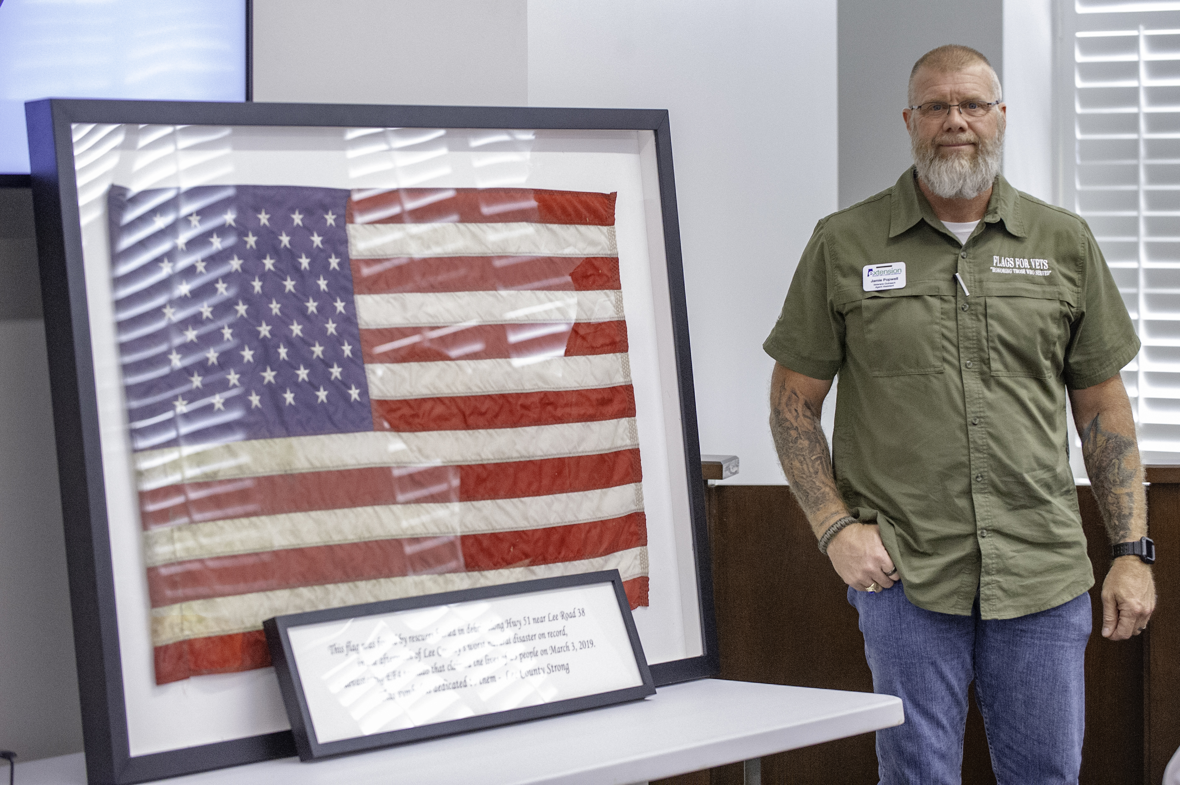 Opelika’s Jamie Popwell presents flag found in rubble of March 3 tornadoes to members of Lee County Commission