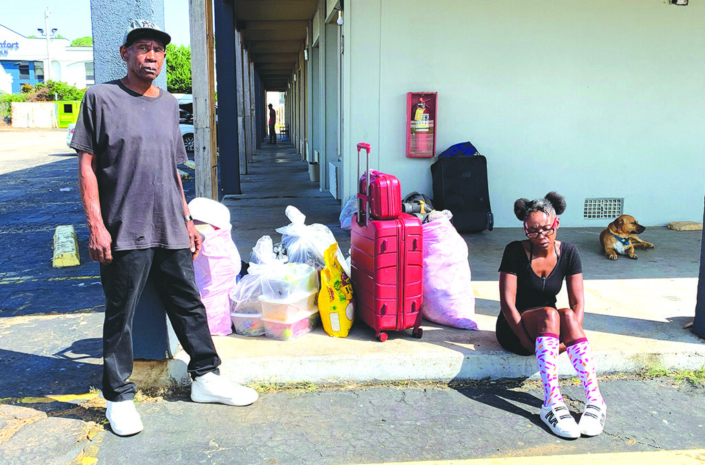 Residents of the Springwood Hotel in Opelika, Alabama, sit amongst their belongings as they try to find a new place to live.